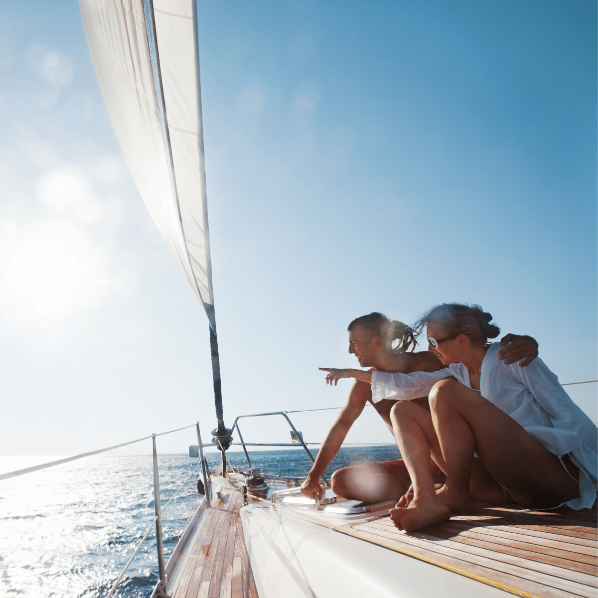 A photo of two people on a sailboat, looking off across the water.